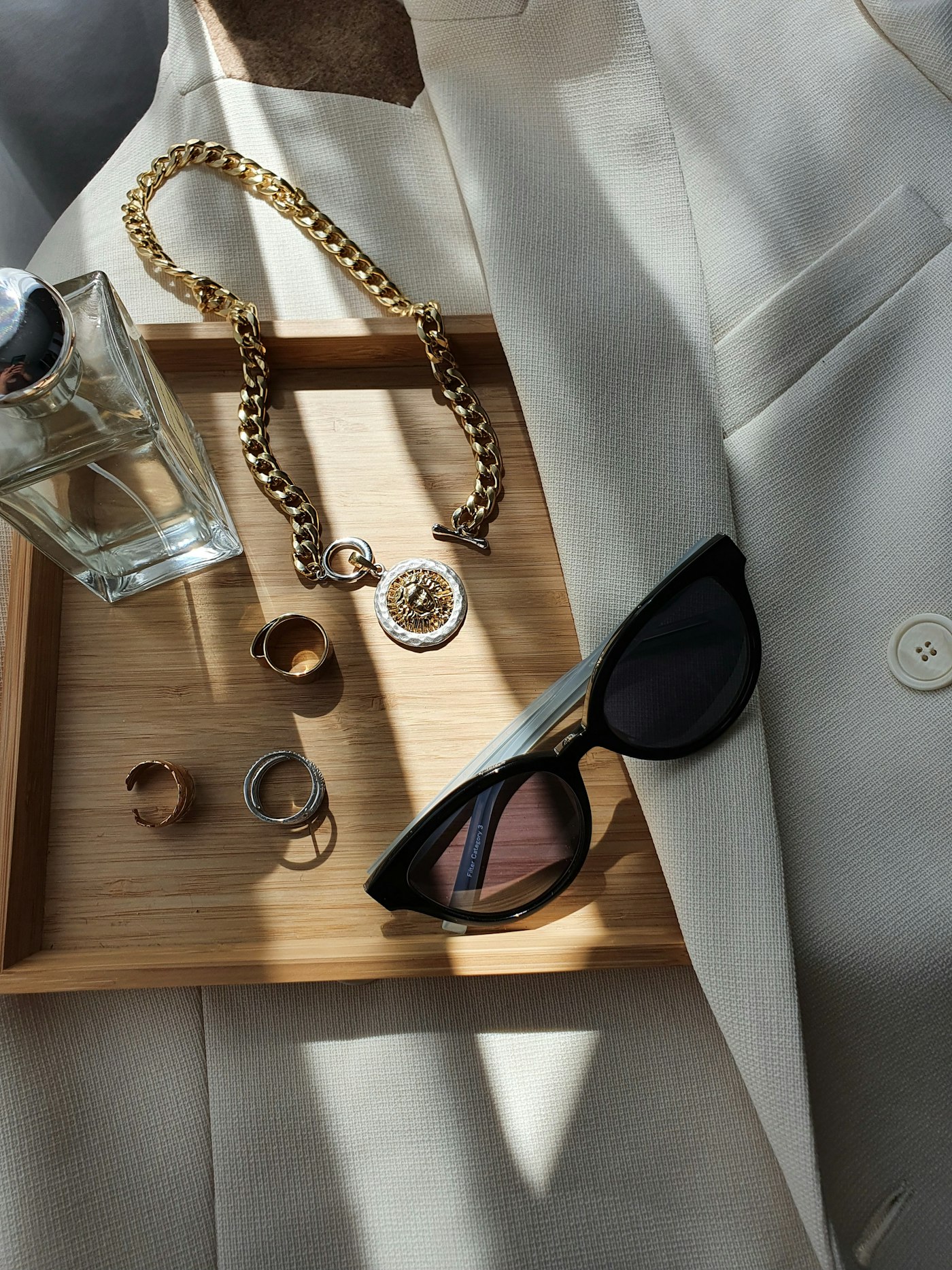 Gold jewellery, sunglasses and a cream blazer